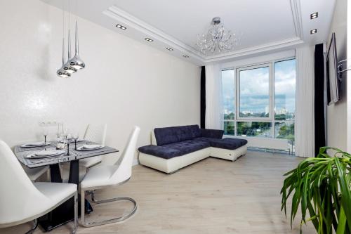 基辅Black&White Apartment in Smart Plaza的客厅配有蓝色的沙发和桌子