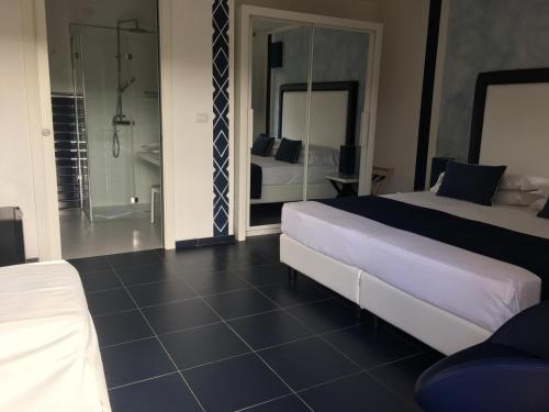 斯廷蒂诺卡拉罗莎俱乐部酒店的一间带两张床的卧室和一间带淋浴的浴室