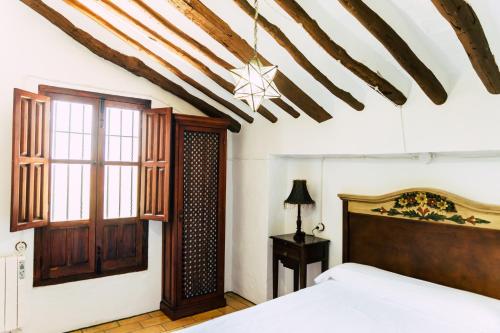 普里埃格·德·科尔多巴Cortijo Abril的一间卧室设有一张床和木制天花板