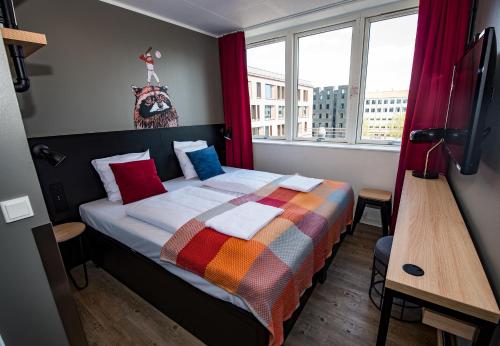 哥本哈根哥本哈根哲奈瑞特酒店的一间卧室配有一张带彩色毯子的床