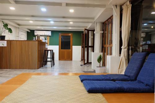 万象Barn Laos Hostel的客厅配有蓝色的沙发和桌子