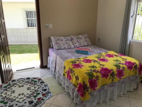 弗洛里亚诺波利斯Pousada Mera的一间卧室配有一张带鲜花被子的床