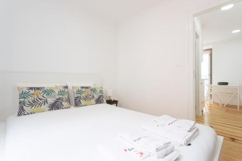 里斯本FLH Mouraria Charming Flat II的卧室配有白色床和毛巾