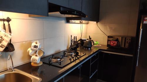 普特拉贾亚Conezion Luxury 3BR for 7pax @IOI Resort Putrajaya的一间带炉灶的厨房 水槽旁的顶部烤箱