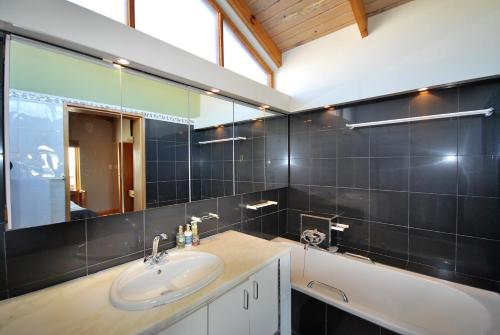 Rand RiflesVilla Winglo的一间带水槽、浴缸和镜子的浴室