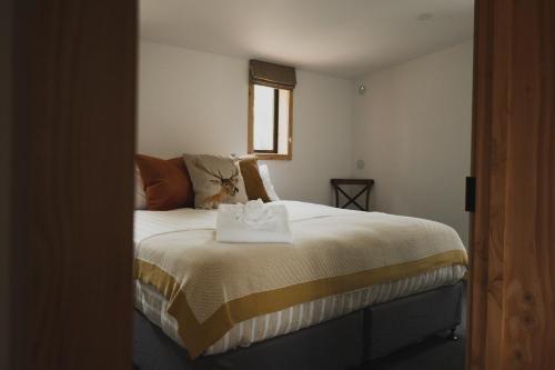 特卡波湖Alpine Lodges的一间卧室配有一张床,床上有毛巾