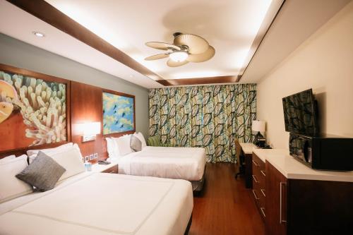 塞班冲浪者度假酒店的酒店客房设有两张床和电视。