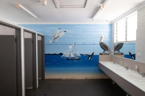 洛坎普顿Rockhampton Backpackers YHA的浴室内有鸟壁画和小船
