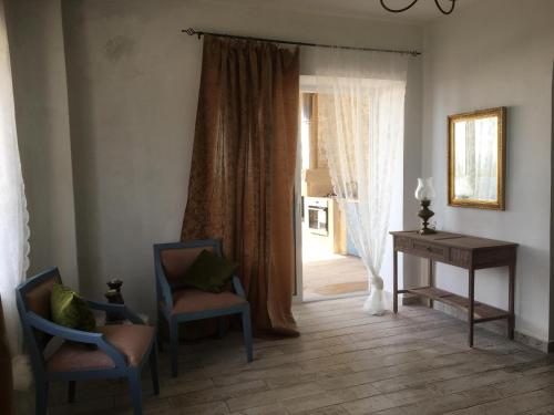 埃拉福尼西岛Elafonisi Villa above the Beach的客房设有两把椅子、一张桌子和一个窗户。