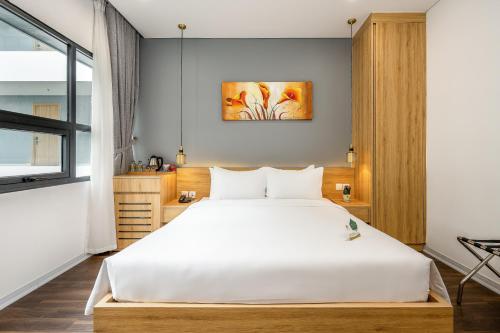 岘港白玉兰酒店的卧室配有一张白色大床