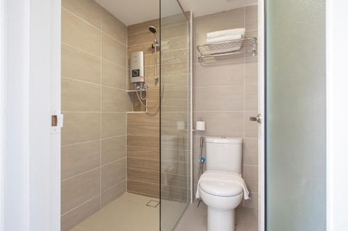 关丹Adena Beach Resort的一间带卫生间和玻璃淋浴间的浴室