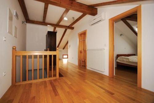 Vremski BritofApartments Janks的客房设有一张床和铺有木地板的走廊