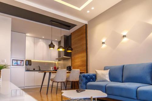 诺维萨德Dali Apartments Pupin Palace的一间带蓝色沙发的客厅和一间厨房