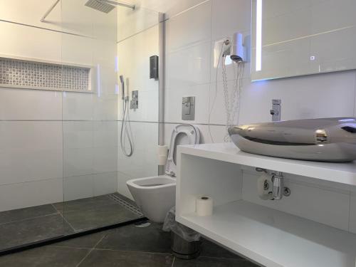 普拉亚普莱伊亚诺公寓酒店的白色的浴室设有水槽和卫生间。