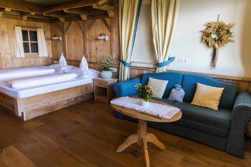 圣杰内肖阿泰西诺舍格尔伯格霍夫酒店的一间卧室配有一张床、一张沙发和一张桌子