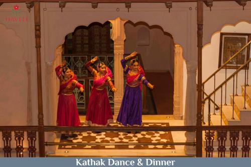 新德里Haveli Dharampura - UNESCO awarded Boutique Heritage Hotel的三个女人在舞台上表演舞蹈