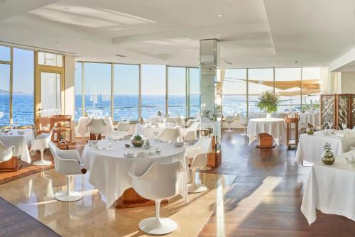 马赛贝迪尼斯贝斯达酒店的一间设有白色桌椅的海洋餐厅
