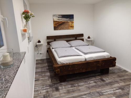 戈赫Lebensfreude的一间卧室配有一张带白色床单的木床