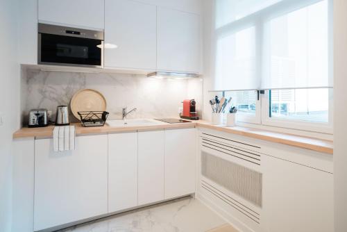 巴黎SUITE GIDE : au cœur de la Rive Gauche, neuf, design, 2/4 personnes的白色的厨房配有白色橱柜和窗户