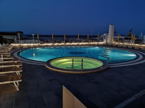 切塞纳蒂科Hotel David的夜间大型游泳池,灯光照亮
