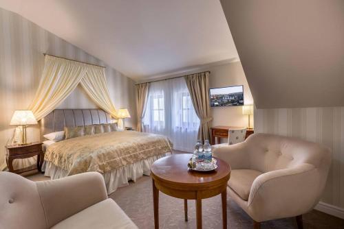 布拉格Hotel Hoffmeister的一间卧室配有一张床、两把椅子和一张桌子