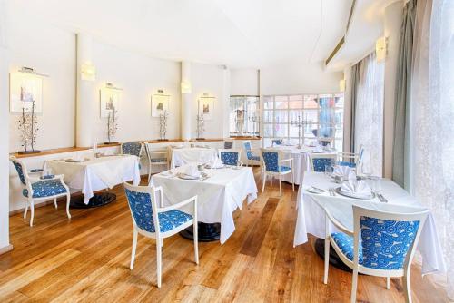 布拉格Hotel Hoffmeister的用餐室配有白色的桌子和蓝色的椅子