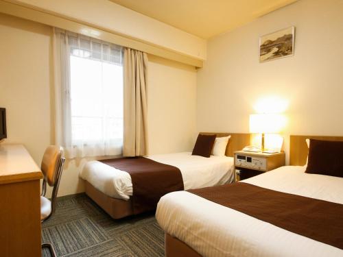 大阪新大阪太阳石酒店 的酒店客房设有两张床和窗户。