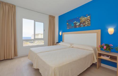 洛思坎加约斯坎加胡斯中心公寓酒店的一间卧室设有一张蓝色墙壁的大床