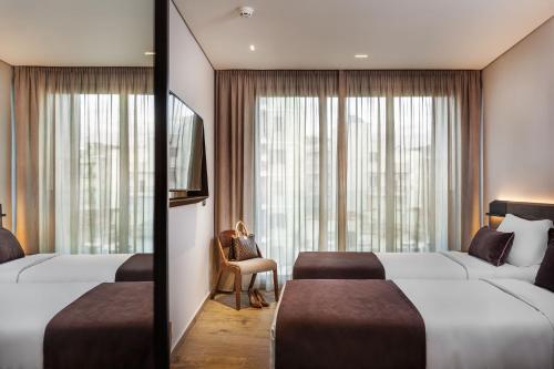 塞萨洛尼基Imperial Plus Urban Smart Hotel Thessaloniki的酒店客房设有两张床和窗户。