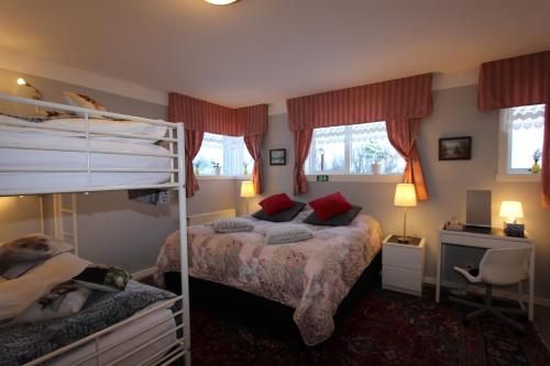 Hjalteyri维京乡村俱乐部乡村民宿的一间卧室配有两张双层床和一张书桌
