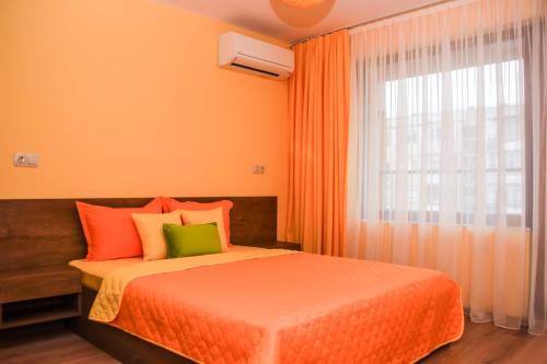 布尔加斯Sunny的一间卧室配有橙色的床和窗户。