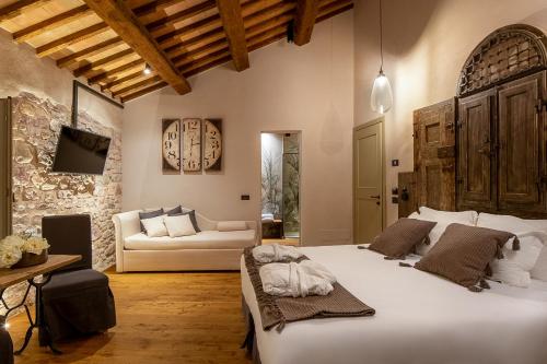 阿西西Borgo Antichi Orti Assisi的卧室配有一张白色的大床和一张沙发。