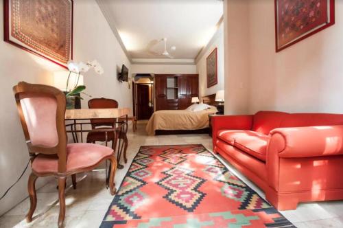 库埃纳瓦卡Orchidelirium Casa Hotel & Salud Estética的一间带红色沙发的客厅和一间用餐室