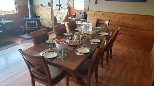 塔尔基特纳Caribou Lodge Alaska的一张带椅子的木桌和一间带壁炉的用餐室