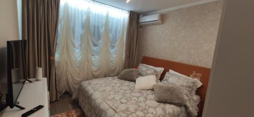 布加勒斯特Casa LUX的卧室配有带枕头的床铺和窗户。