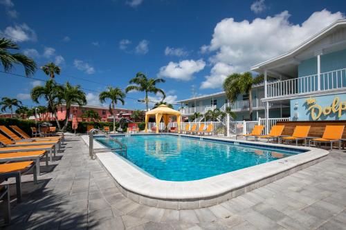 圣徒皮特海滩圣皮特海滩套房酒店的一座带椅子的度假村的游泳池和一座建筑