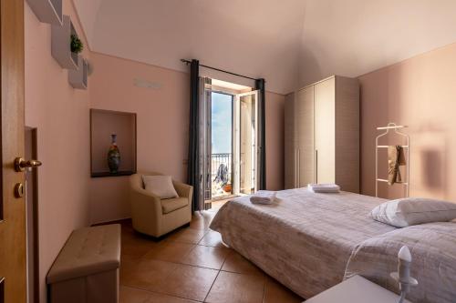 拉维罗Casa Vacanza da Giggino的卧室配有床、椅子和窗户。
