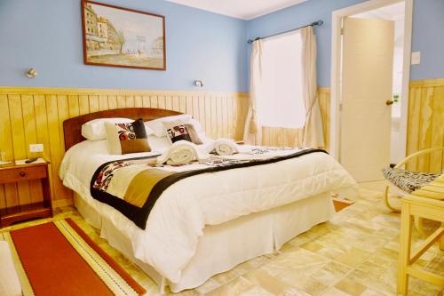 纳塔列斯港Patagonia Swiss House的一间卧室配有一张带蓝色墙壁的大床