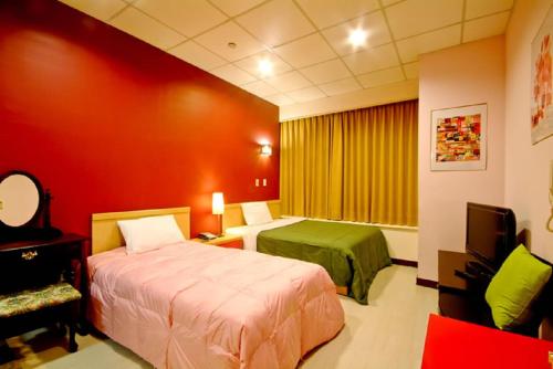 高雄空中城都會商旅的酒店客房设有两张床和电视。