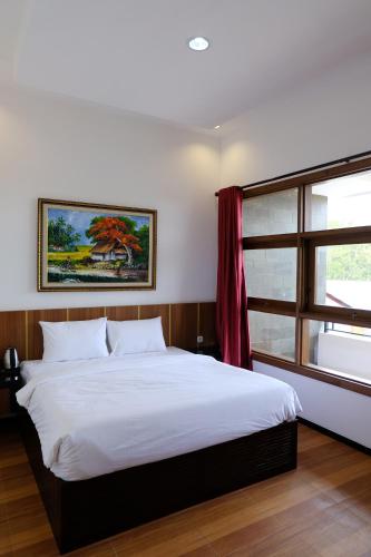 BondowosoBaratha Hotel & Resto的卧室设有一张白色大床和一扇窗户。