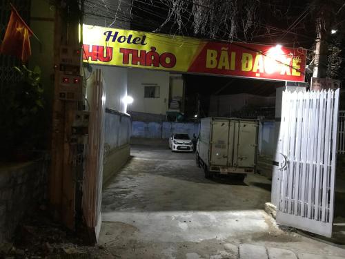 潘郎Khách sạn Thu Thảo的车库,有车停在一个好莱坞酒吧标志下