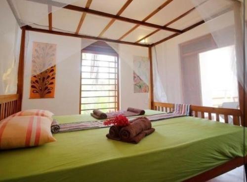 坦加拉Hidden Garden Tangalle的一张大绿色的床,位于一个窗户的房间
