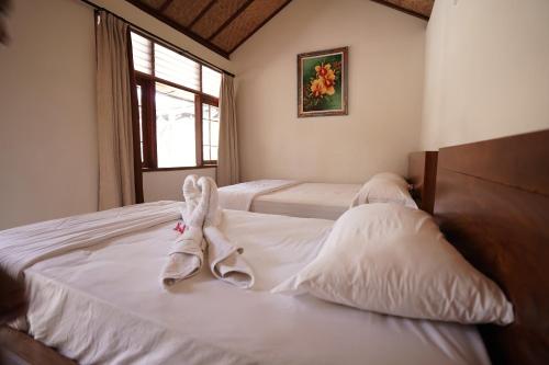 珀尼达岛Griya Nusa的一间卧室配有两张带毛巾的床
