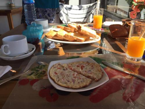 努沃勒埃利耶Chez Allen的一张桌子,上面放着一盘食物、面包和橙汁