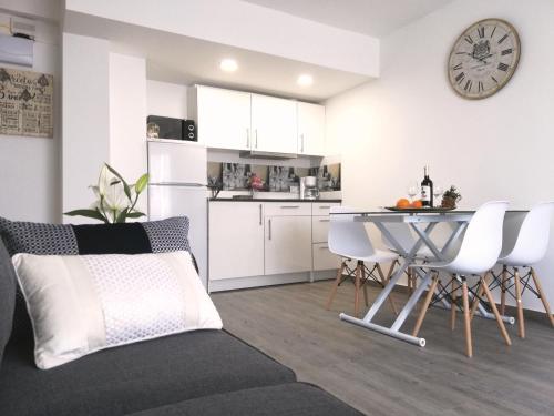 托雷维耶哈Beachfront modern and spacious apartment的厨房以及带桌椅的起居室。