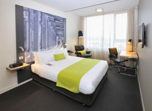 墨尔本墨尔本蒂埃里街美居酒店的配有一张床和一张书桌的酒店客房