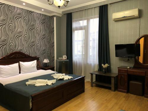 第比利斯伯纳斯酒店的一间卧室配有一张带镜子的床和一台电视