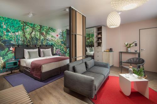 布达佩斯Cortile Hotel - Adults Only的一间卧室配有一张床、一张沙发和一把椅子