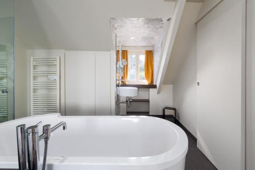 迪纳尔迪迪埃美丽儿餐厅酒店的浴室配有白色浴缸和水槽