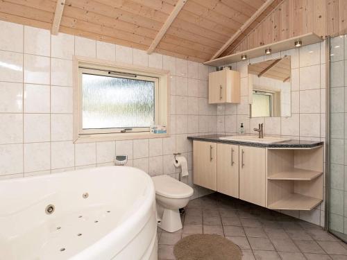 克兰尼茨Three-Bedroom Holiday home in Rødby 38的带浴缸、卫生间和盥洗盆的浴室